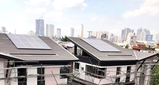 Metal roofing with solar panels on homes with city skyline