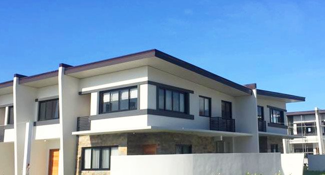 Completed townhouse roofing with metal roof and gutter system